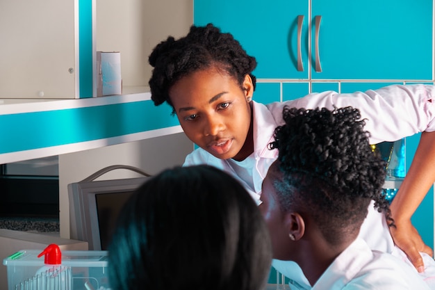 Female African medical students, young graduates in research, medical test lab performing various testing on samples. Nucleic acid pcr test to detect novel coronavirus, new blood test for antibodies.