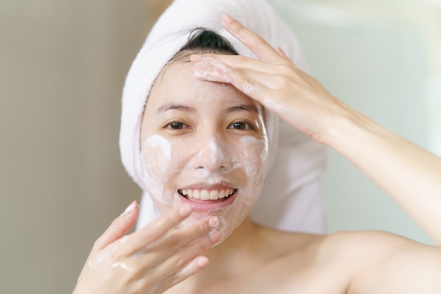 Female applies foaming cleanser, clean healthy skin.