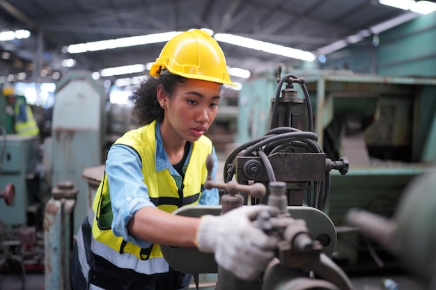 Female apprentice in metal working factory, Portrait of working female industry technical worker or engineer woman working in an industrial manufacturing factory company.