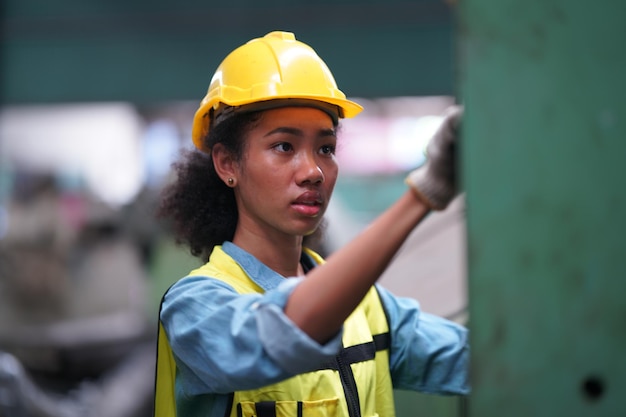 Female apprentice in metal working factory, Portrait of working female industry technical worker or engineer woman working in an industrial manufacturing factory company.