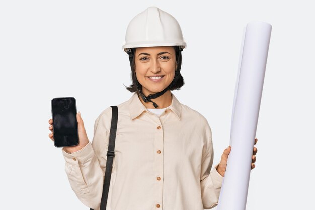 Photo female architect with blueprints and smartphone in studio