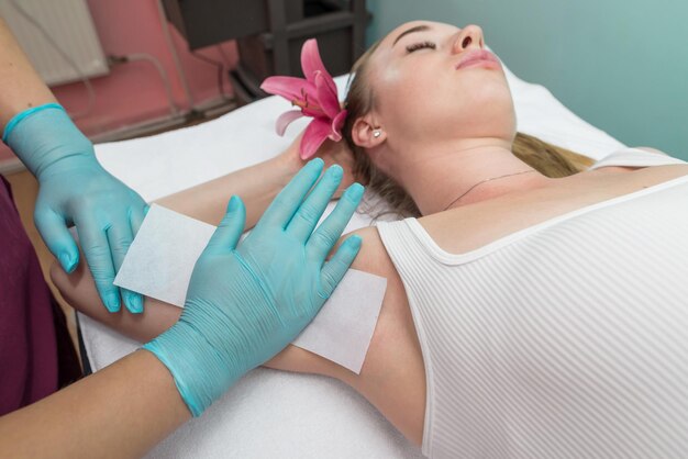 Female armpit depilation in a beauty salon