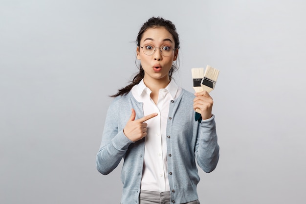 Female art teacher pointing at brushes