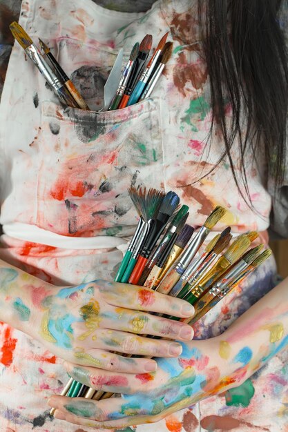 Photo female artist hands with paint brushes