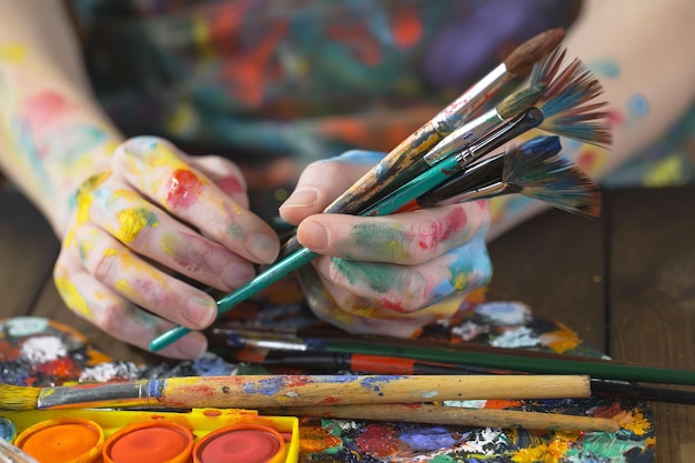 Female artist hands with paint brushes