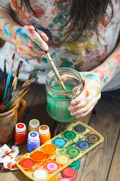 Female artist hands with paint brushes