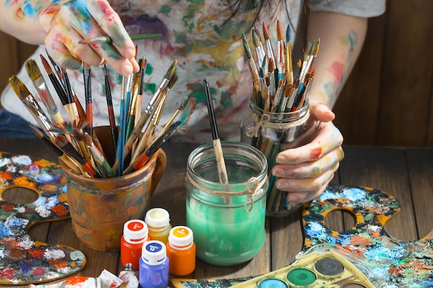 Female artist hands with paint brushes