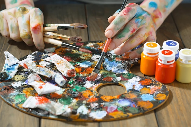 Female artist hands with paint brushes