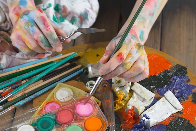 Female artist hands with paint brushes