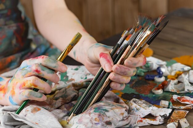 Female artist hands with paint brushes