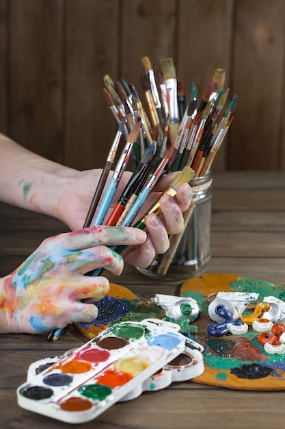 Female artist hands with paint brushes