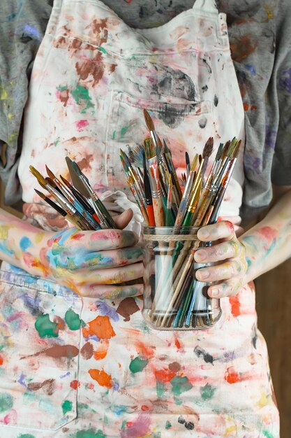 Photo female artist hands with paint brushes