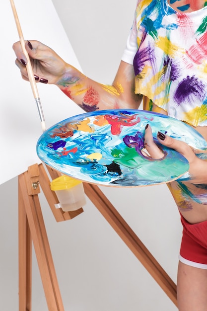 Female artist holding palette with paints for drawing