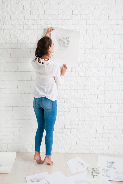 Female artist looking at her work in workshop