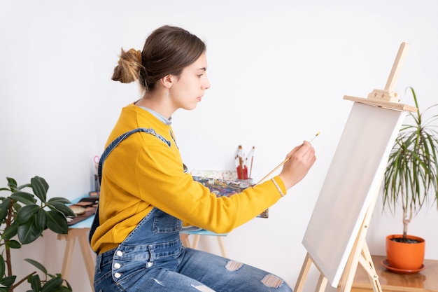 写真 ワークショップの白い背景で絵画の女性アーティスト