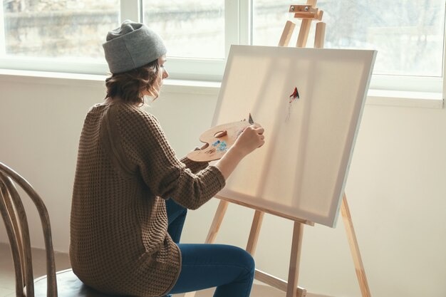 Female artist painting in workshop