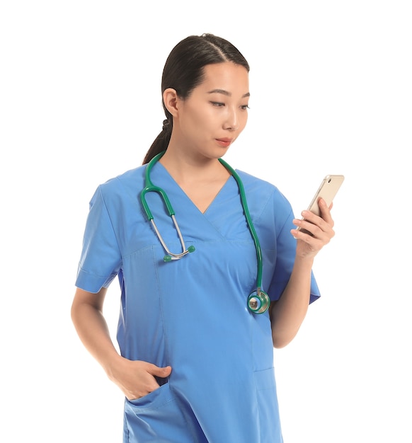 Female Asian doctor with mobile phone on white