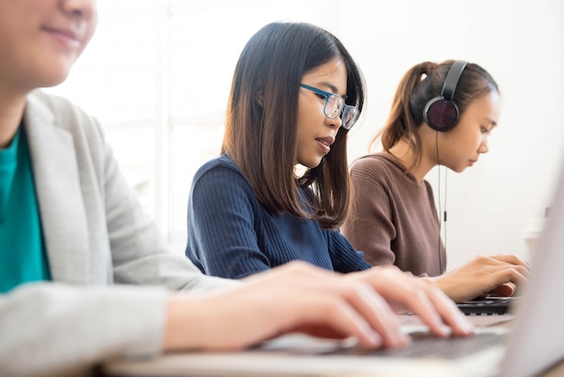 Studentesse asiatiche che fanno lavoro online nell'aula