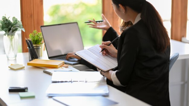 Female assistant and her manager working together in the office workplace