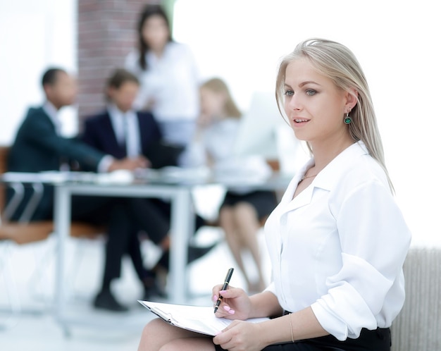 Female assistant with the minutes of the meeting on the background of the office