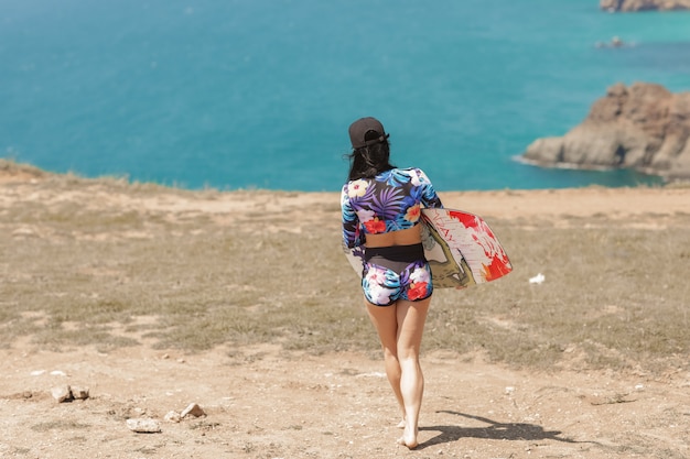 Female athlete on the beach in sports equipment for swimming on the beach