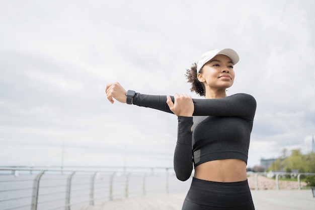 A female athlete does active cardio fitness exercises uses a fitness watch