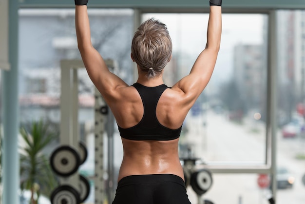 Photo female athlete doing pull ups  chinups in the gym