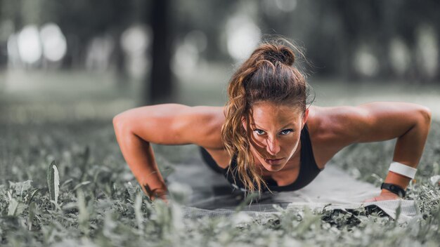 Female athlete doing pushups outdoors