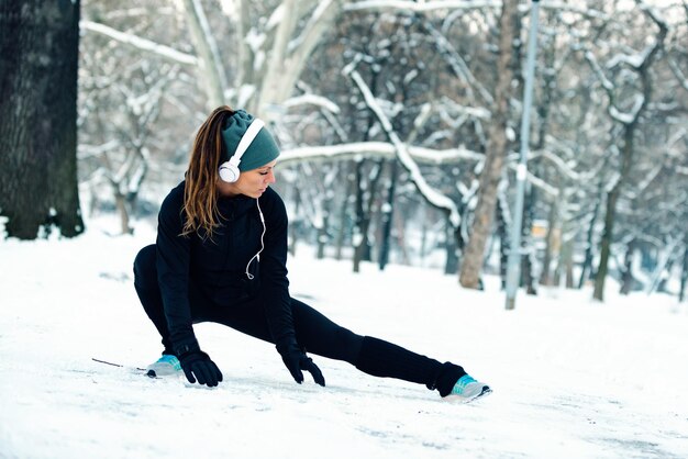 Female athlete exercising in park in winter