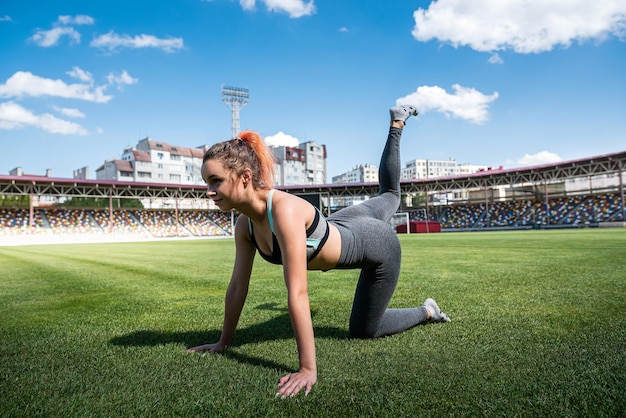 女性アスリートは、シティスタジアムのアクティブなライフスタイルでスポーツトレーニングヨガやピラティスエクササイズを行います