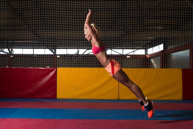 Photo female athlete performing a long jump in gym  one of the best jumping exercise for vitality