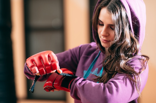 Foto atleta femminile che indossa i guantoni da boxe in palestra