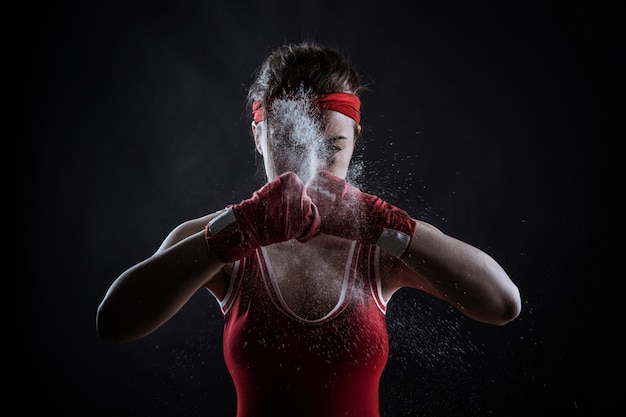 Foto atleta femminile in bende rosse boxe e abbigliamento sportivo, vista frontale. concetto di sport di combattimento