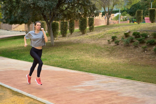 Photo female athlete running alone on park road floating