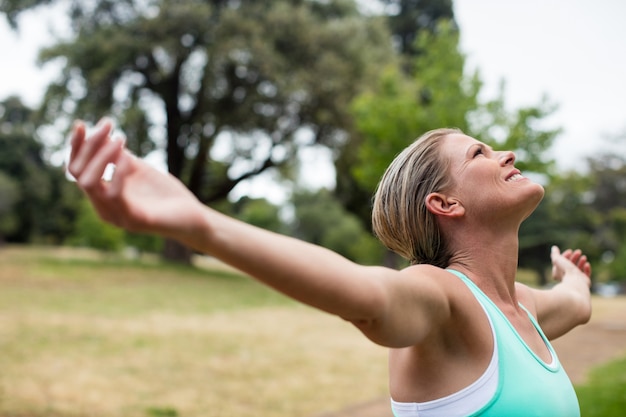 Atleta femminile con le armi stese in parco