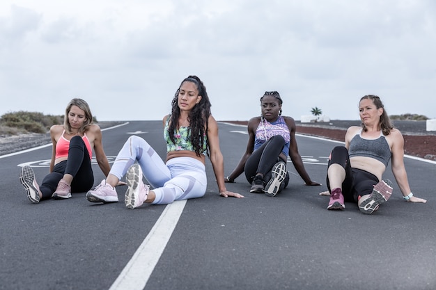 female athletes doing warm-up exercises on the road