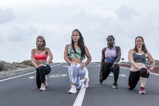 Photo female athletes doing warm-up exercises on the road