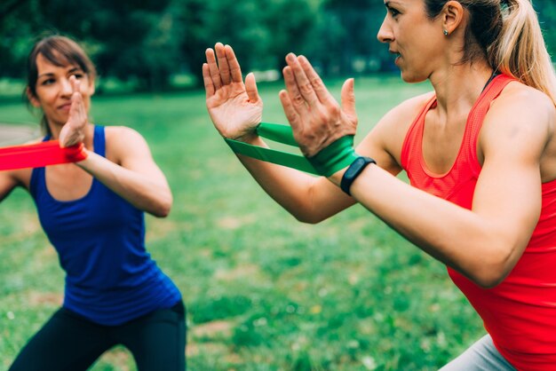 Foto atlete femminili che si esercitano con bande di resistenza nel parco