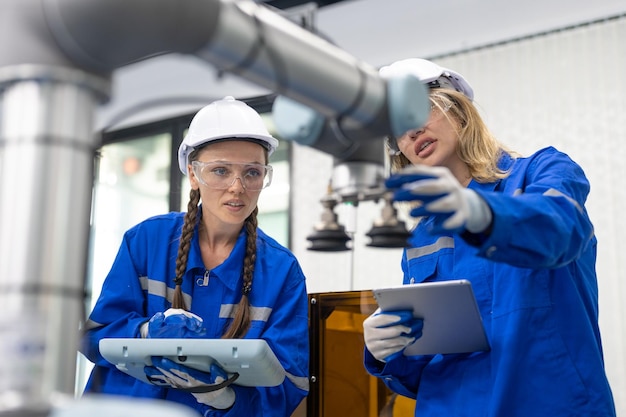 Женщина-инженер по автоматизации проверяет и осматривает сварочный аппарат робота-манипулятора на заводе