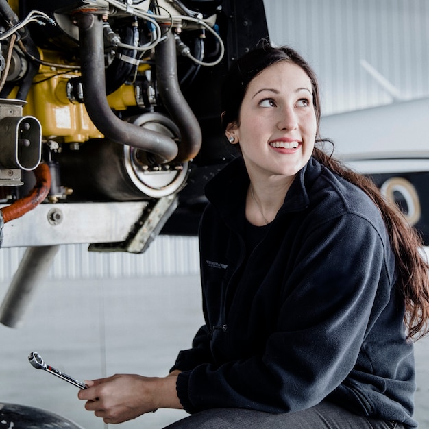 Female aviation technician repairing the motor