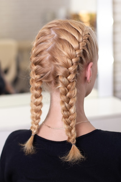 Photo female back with blonde braided hairstyle in hairdressing salon