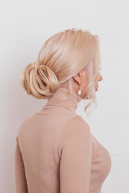 Female back with blonde hair and fashion hairstyle in beauty salon