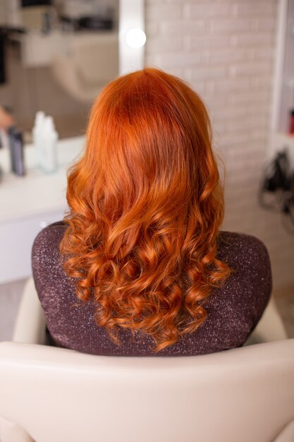 Female back with long, curly, red hair