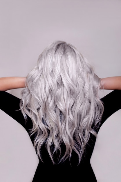 Female back with long curly silver blonde hair