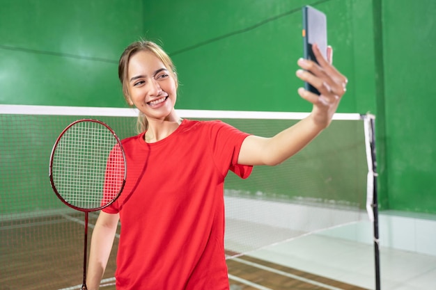 Female badminton player in red selfie with a smartphone