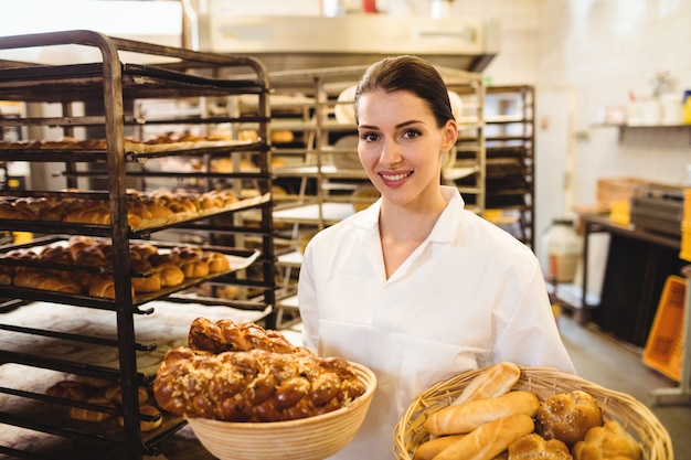 Photo female baker holding basket of sweet foods