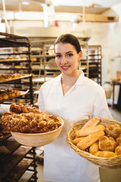 Female baker holding basket of sweet foods