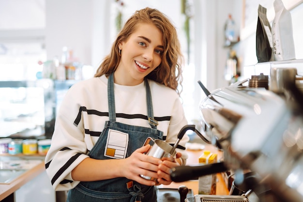 Female barista making coffee in a coffee machine conception of business and service takeaway food