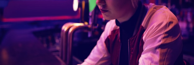 Female bartender using digital tablet at bar counter