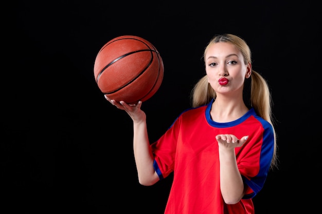 Female basketball player in sport clothes with ball on black\
surface exercise game athlete